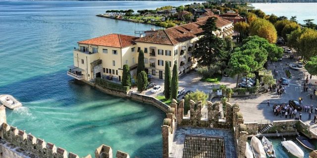 Sirmione tra il lago di Garda, il Castello Scaligero e il cartello sul bacio
