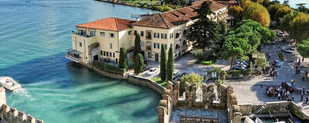 Sirmione tra il lago di Garda, il Castello Scaligero e il cartello sul bacio